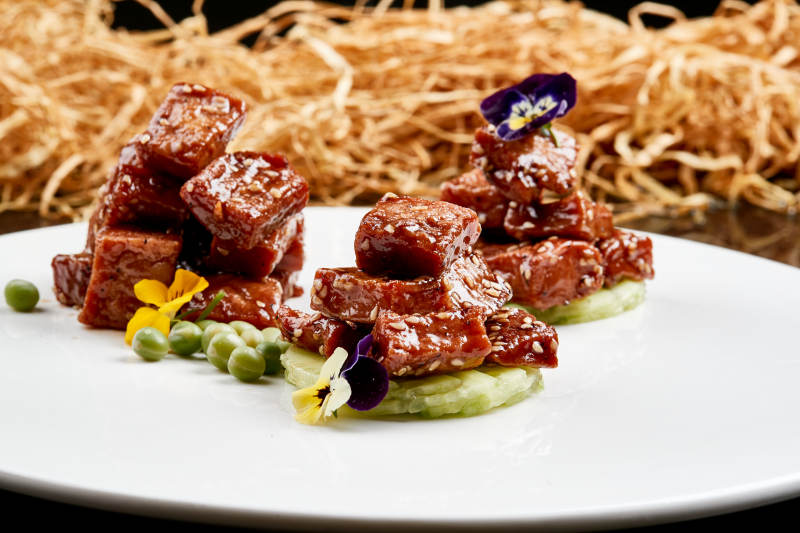 白色瓷盘装的酱腌杏鲍菇