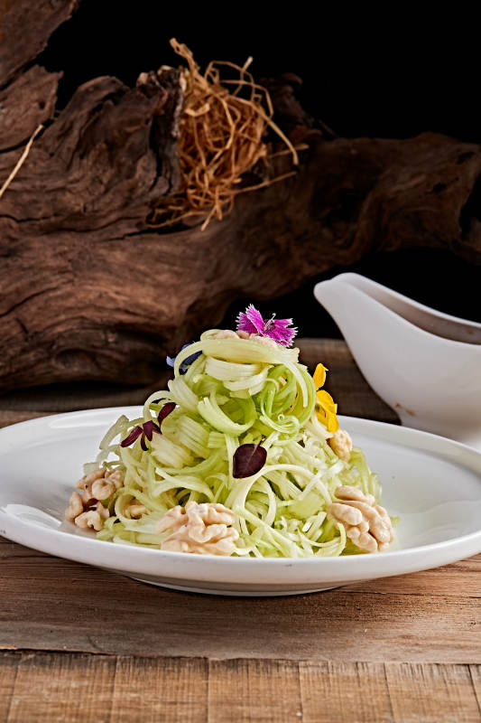 白色瓷盤裝的澆汁桃仁西芹絲