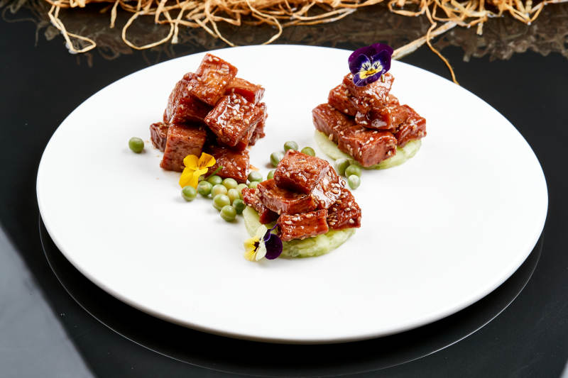 白色瓷盘装的酱腌杏鲍菇