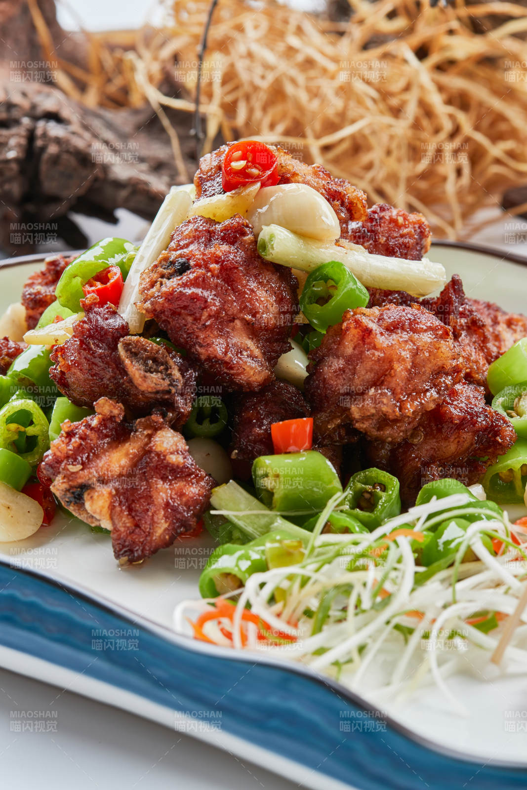 白色瓷盘装的的蒜香米椒烧鸡块