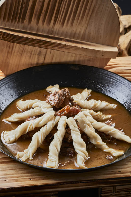 精美餐具装的铁锅炖柴鸡块配面花卷棍儿