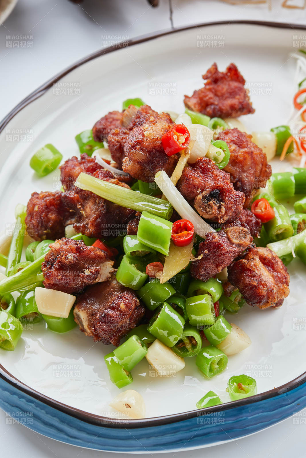 白色瓷盤(pán)裝的的蒜香米椒燒雞塊