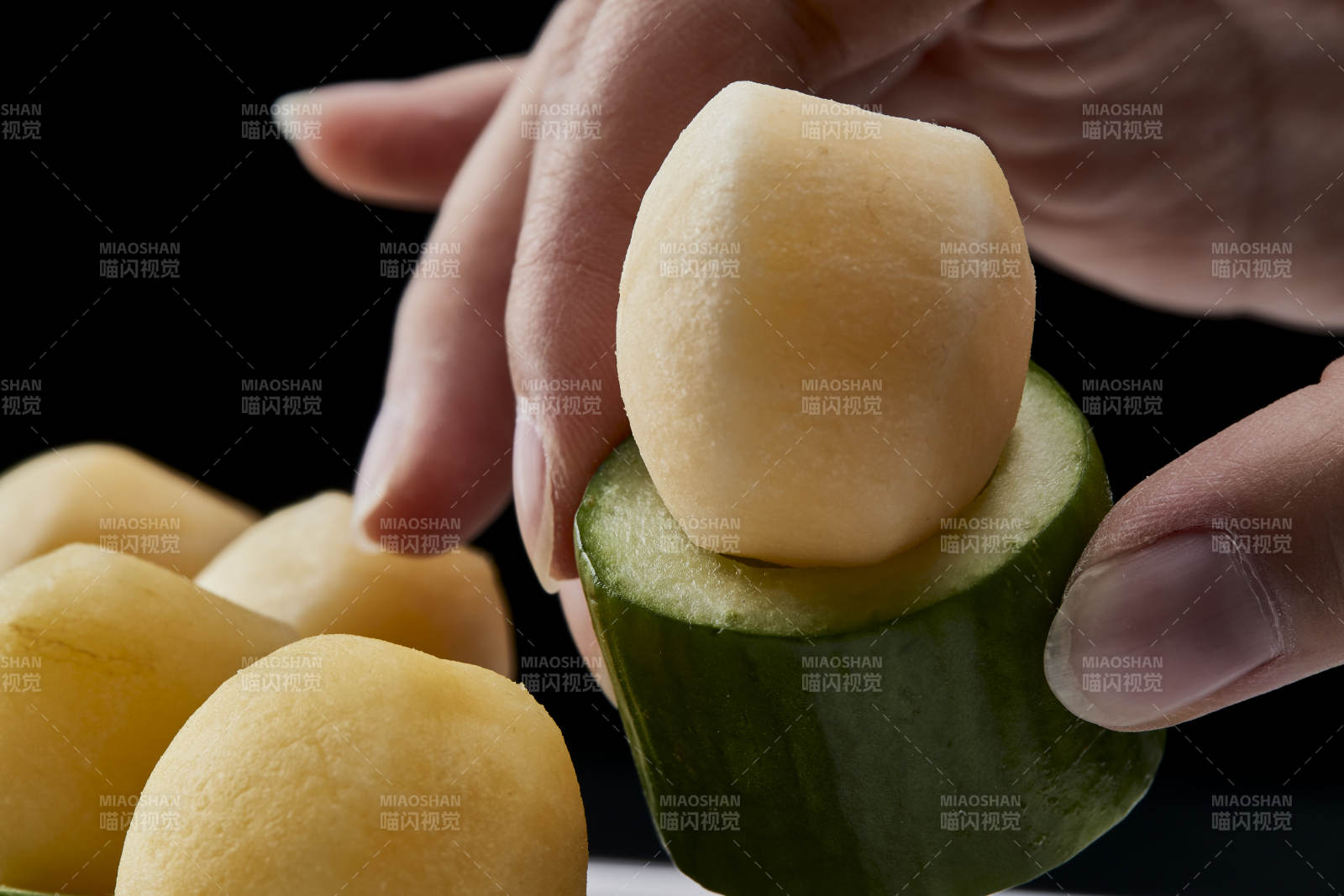 黑色背景上的創意美食手打馬鈴薯球配乳瓜段