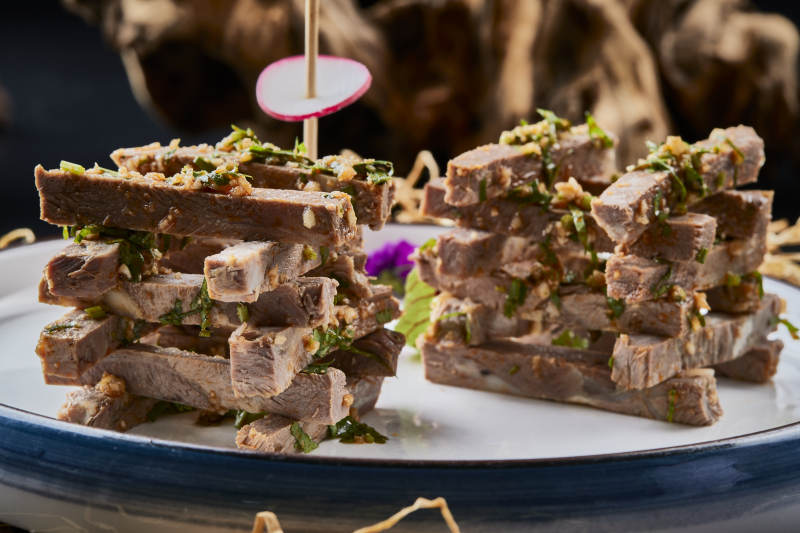 白色圆瓷盘装的蒜香小驴肉