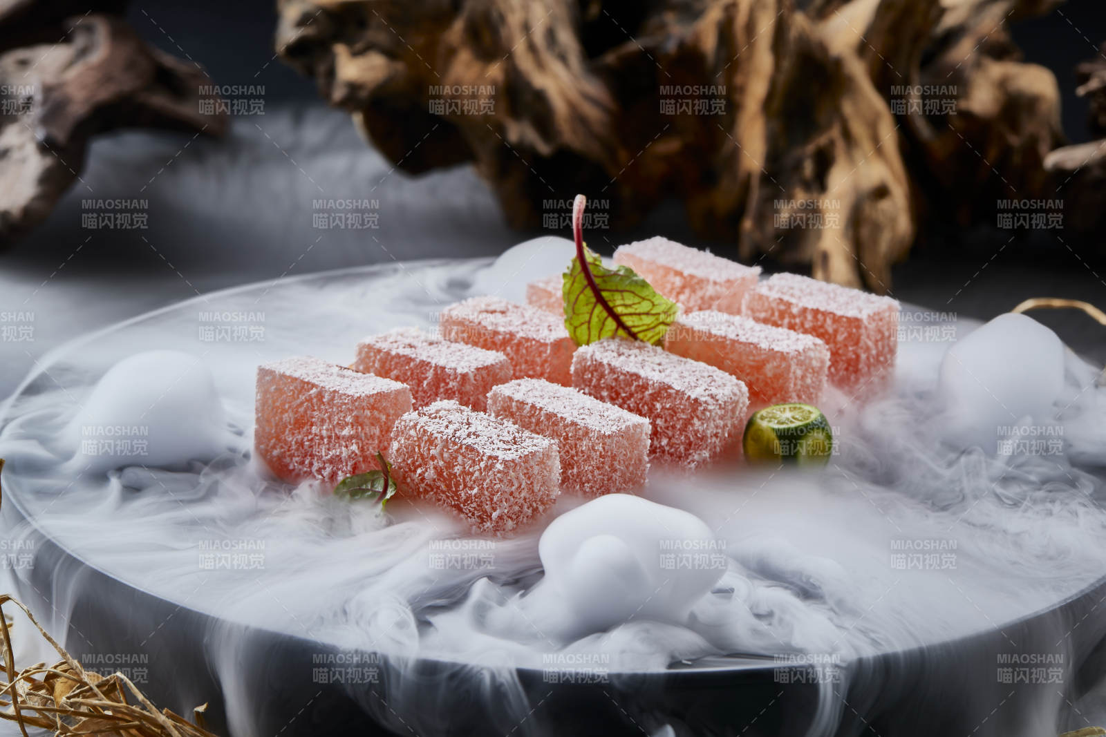 干冰繚繞的黑瓷餐具擺放的番茄糖霜江米糕