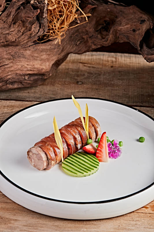 白色瓷盘装的精美凉菜肘花切片