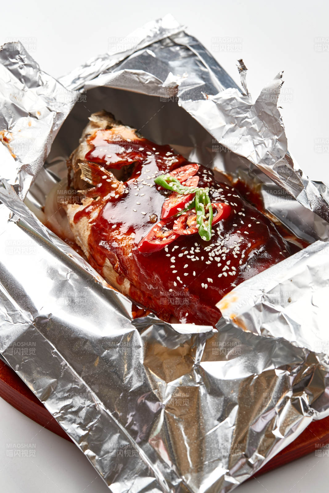 木质托盘摆放的锡纸酱汁烤鲈鱼