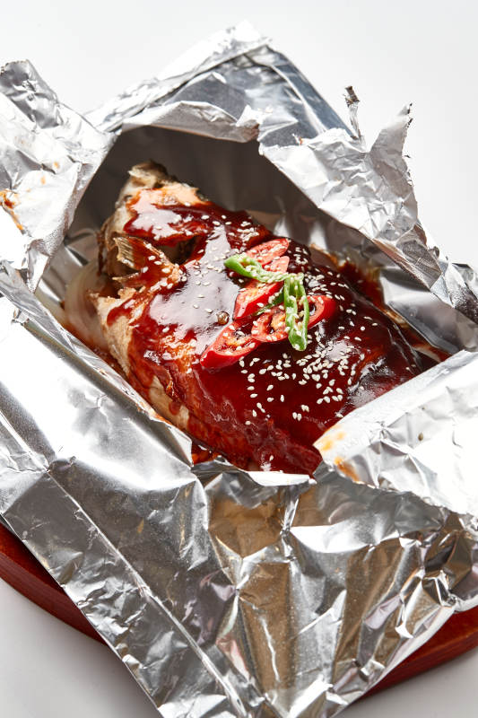 木质托盘摆放的锡纸酱汁烤鲈鱼