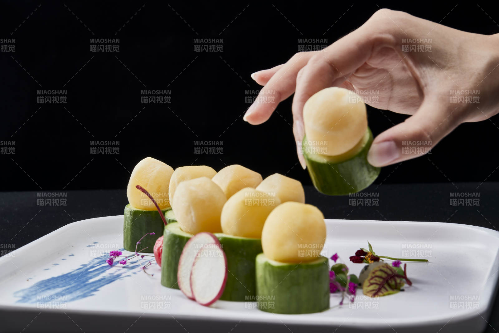 黑色背景上的創意美食手打馬鈴薯球配乳瓜段