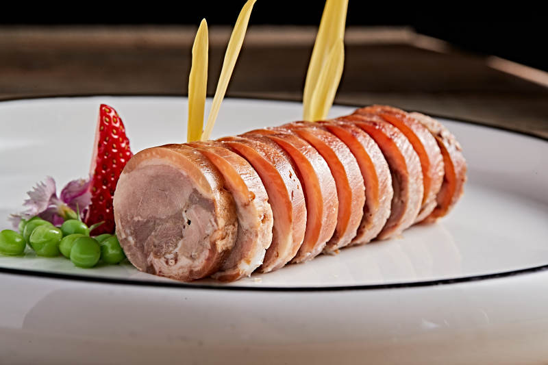 白色瓷盘装的精美凉菜肘花切片