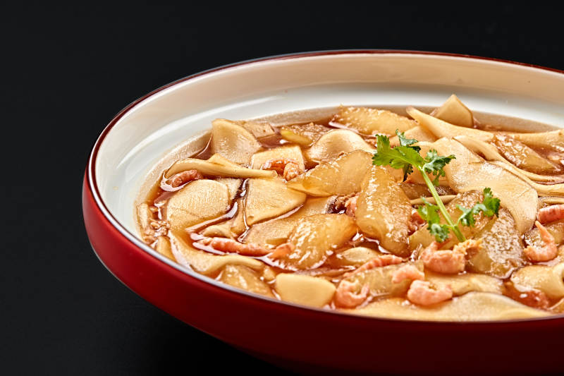 紅釉色瓷盤裝的海米冬瓜燉寬粉