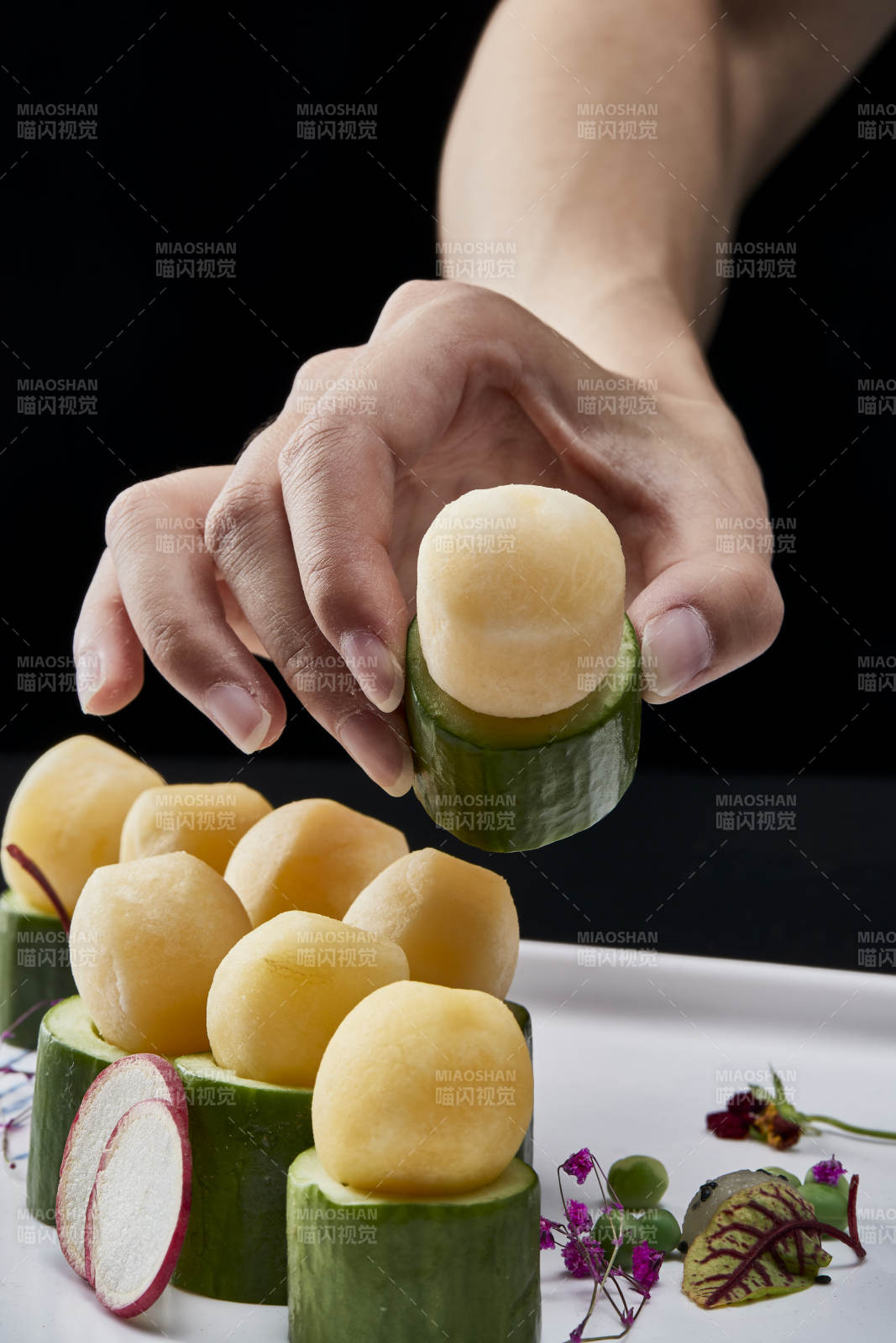 黑色背景上的創意美食手打馬鈴薯球配乳瓜段