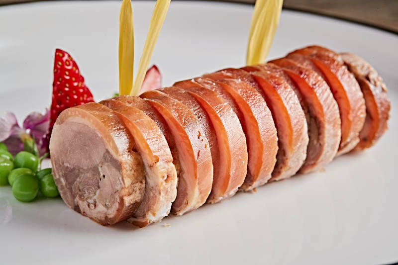 白色瓷盘装的精美凉菜肘花切片