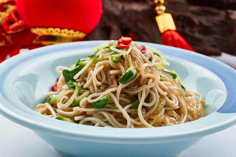 青色瓷餐具裝的黑豆苗涼拌莜面饸饹