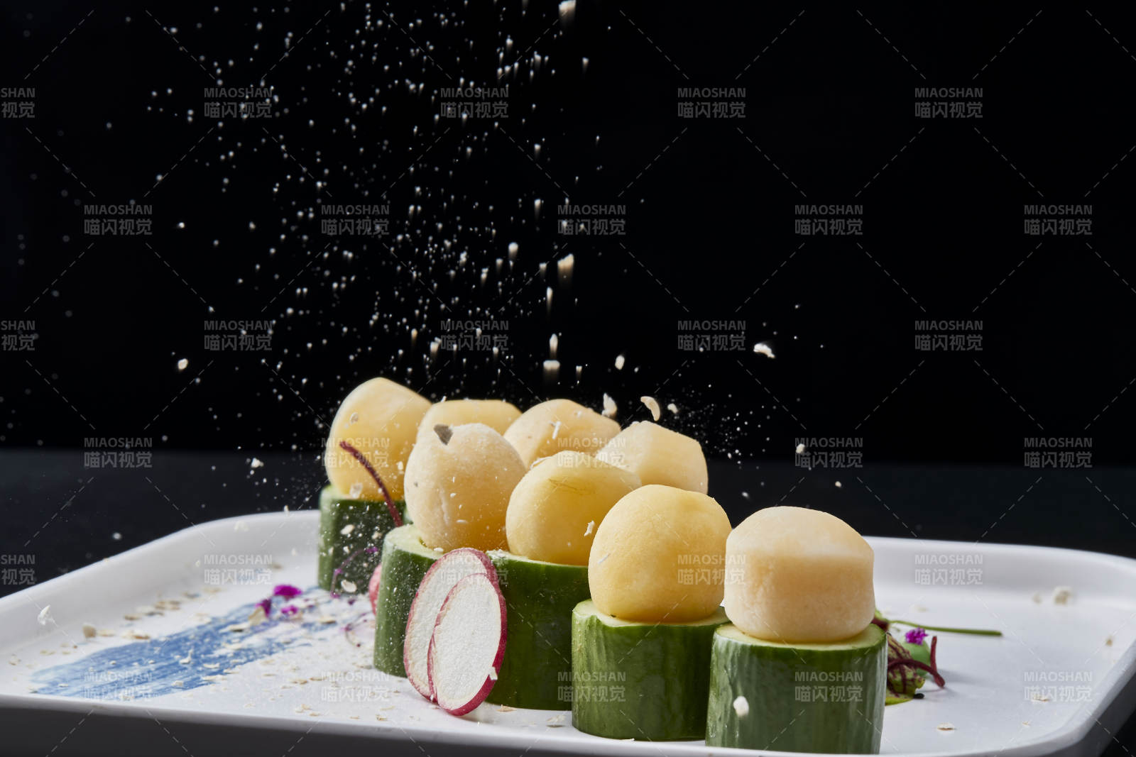 黑色背景上的創(chuàng)意美食手打馬鈴薯球配乳瓜段