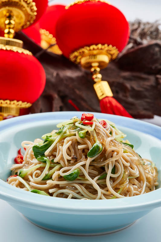 青色瓷餐具裝的黑豆苗涼拌莜面饸饹