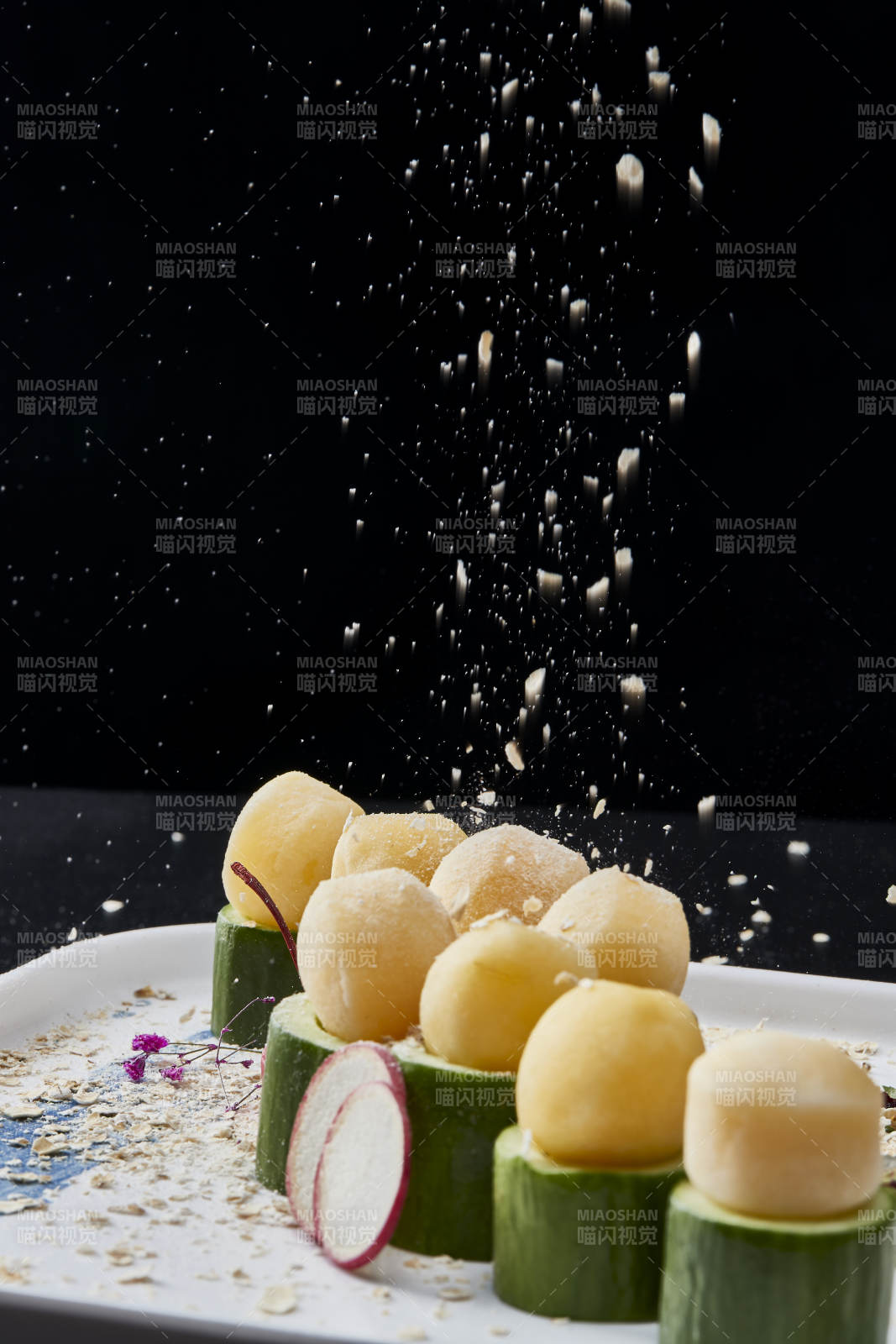 黑色背景上的創(chuàng)意美食手打馬鈴薯球配乳瓜段