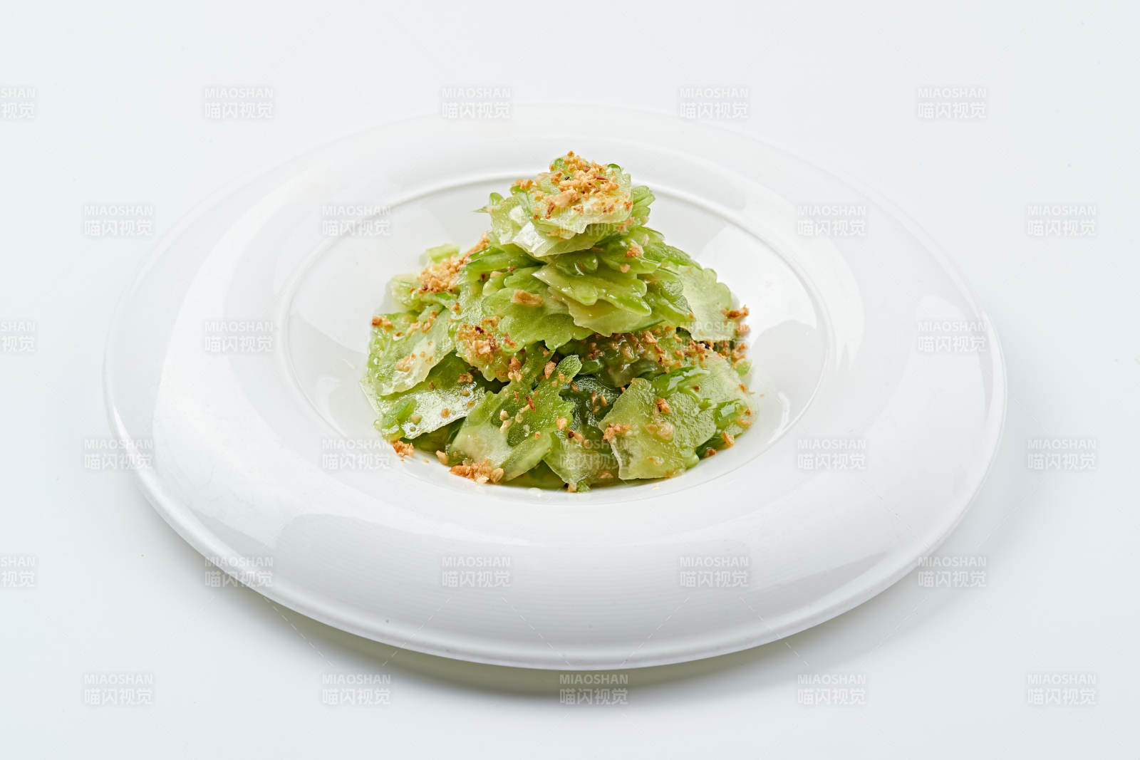 白色瓷盘装的蒜沫凉拌苦瓜片