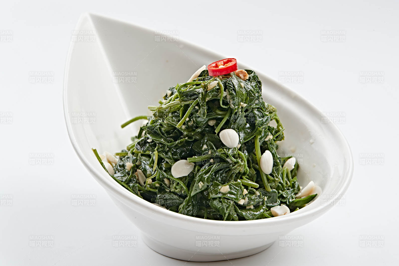 白色瓷盤裝的杏仁熗拌野菜