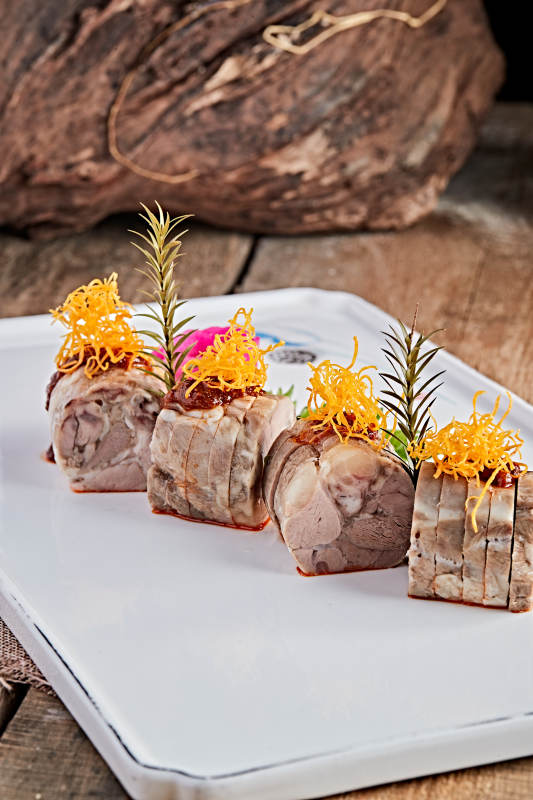 白色瓷盘装的精美凉菜肘花切片