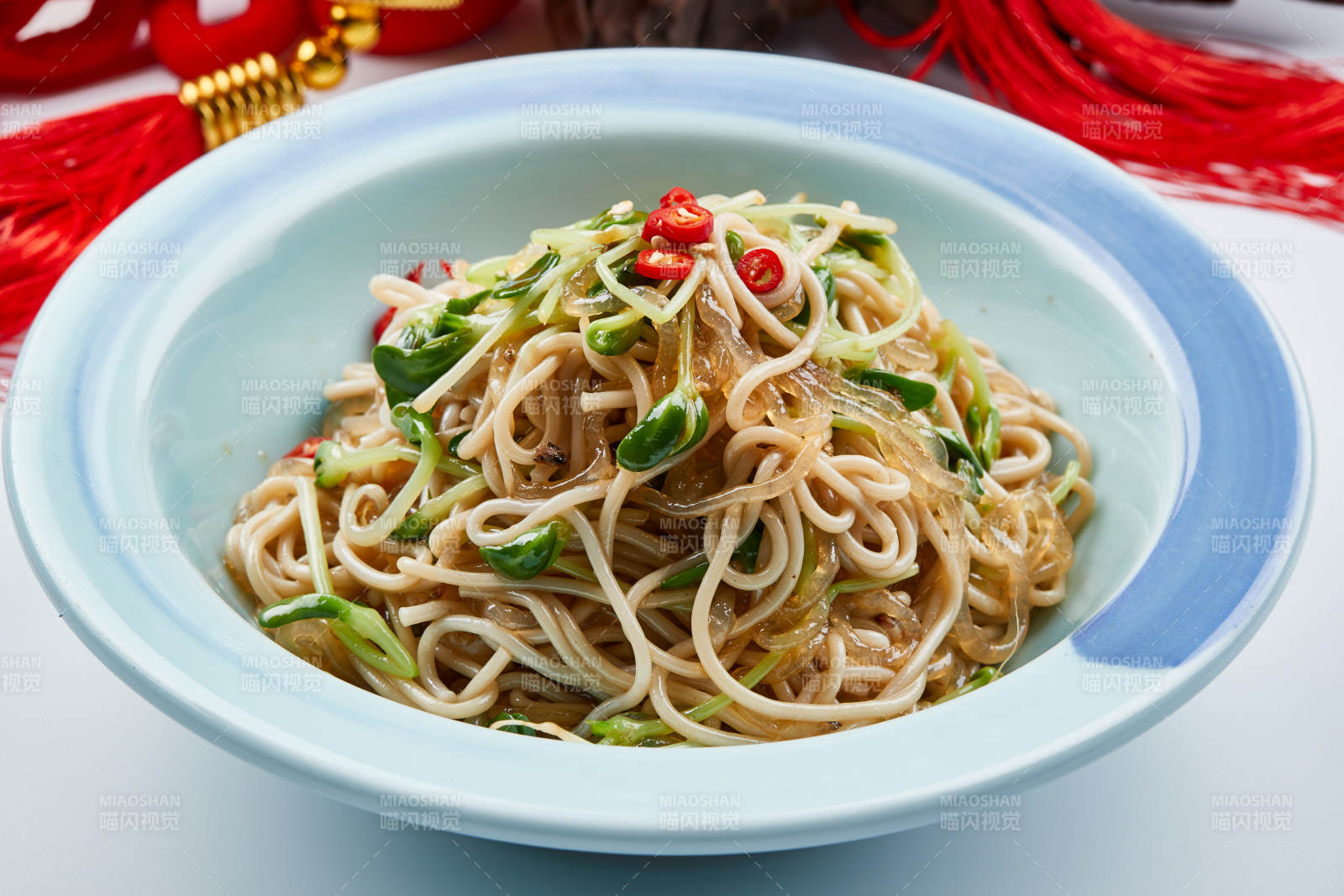 青色瓷餐具裝的黑豆苗涼拌莜面饸饹