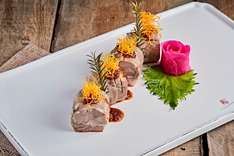 白色瓷盘装的精美凉菜肘花切片