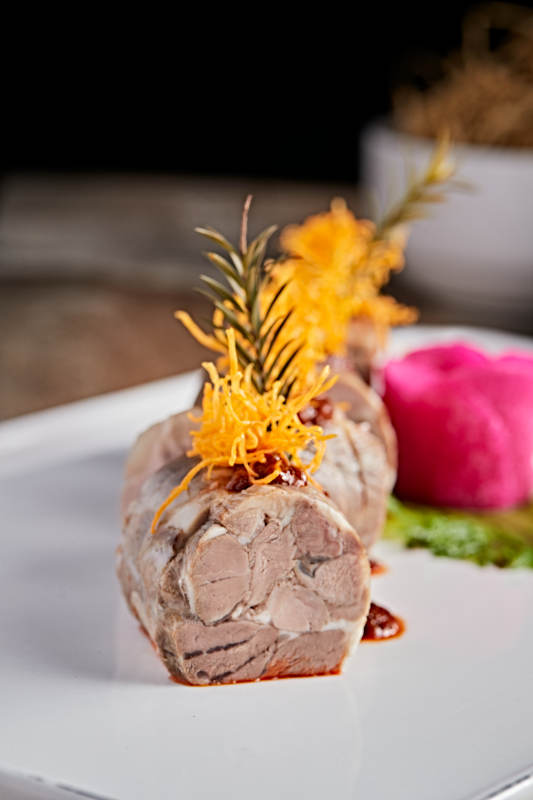 白色瓷盘装的精美凉菜肘花切片