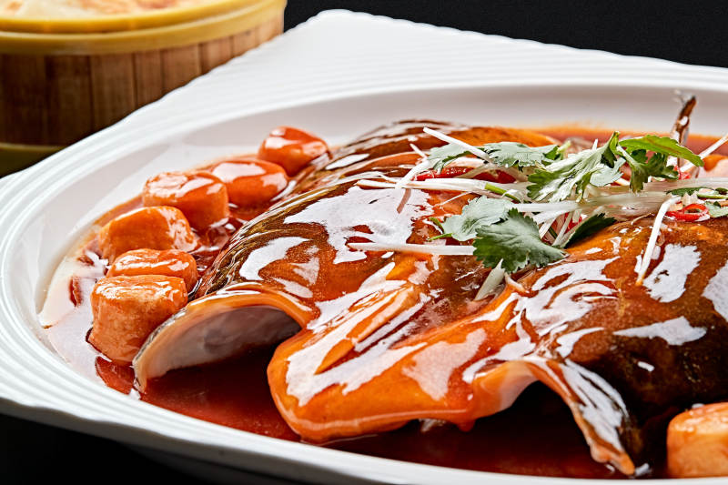 白色瓷盘装的红烧千岛湖大鱼头