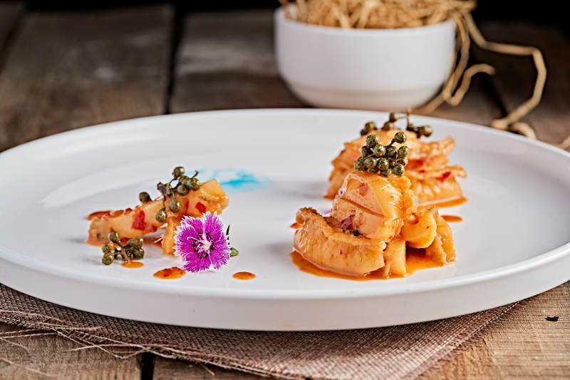 白色瓷盘装的藤椒鸡汁小鲍鱼