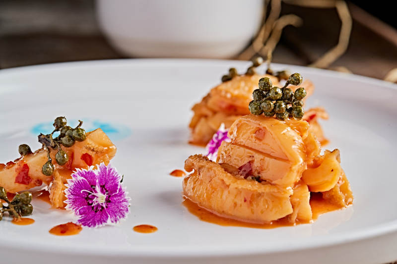 白色瓷盘装的藤椒鸡汁小鲍鱼