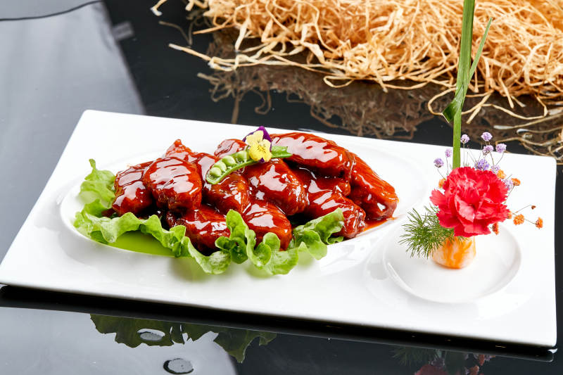 白色瓷盘装的蜜豆酱鸡翅中