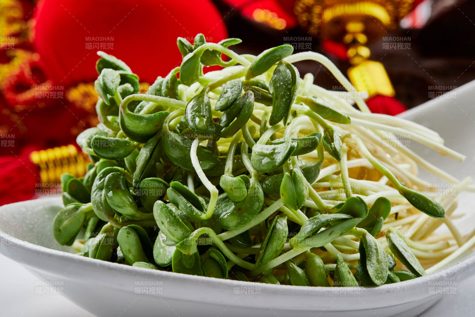 白色瓷盘装的火锅食材香椿苗