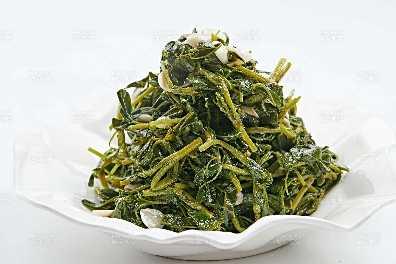 白色瓷盤裝的杏仁熗拌野菜