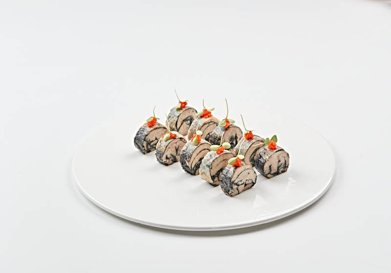 白色瓷盤裝的壓海苔金槍魚卷切片