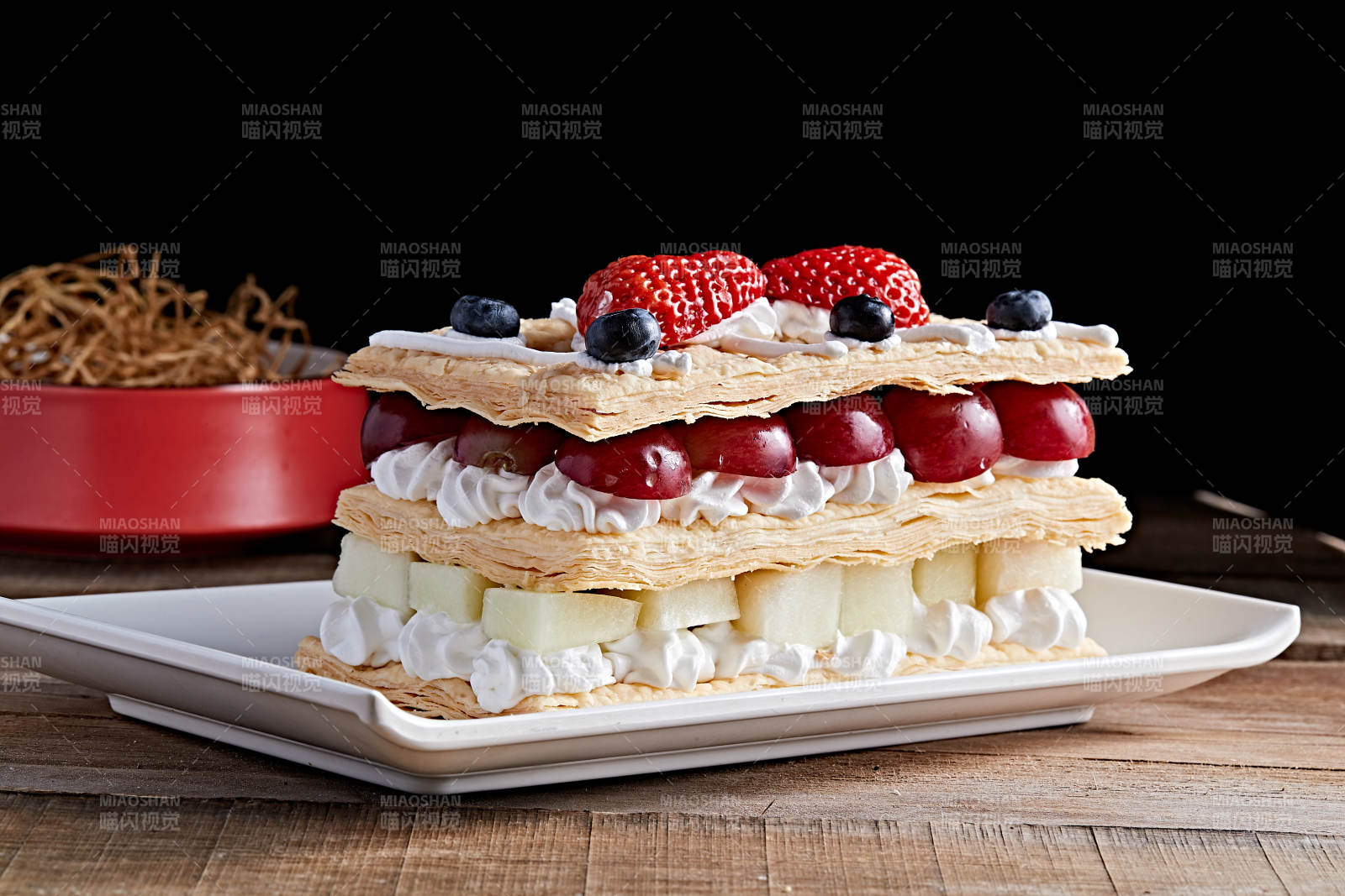 白色瓷盘装的水果戚风奶油拿破仑蛋糕