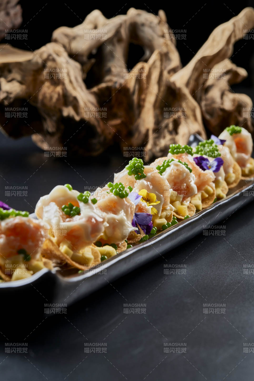 黑色長瓷盤裝的青魚子奶香芝士薯片焗蝦仁