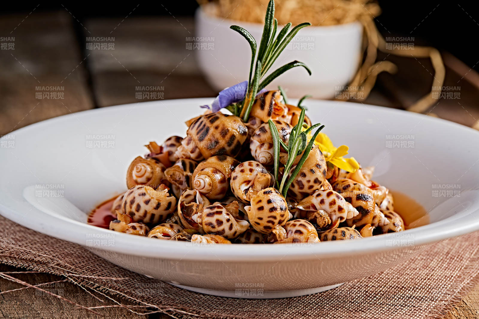 白色瓷盤裝的紅油腌漬小花螺