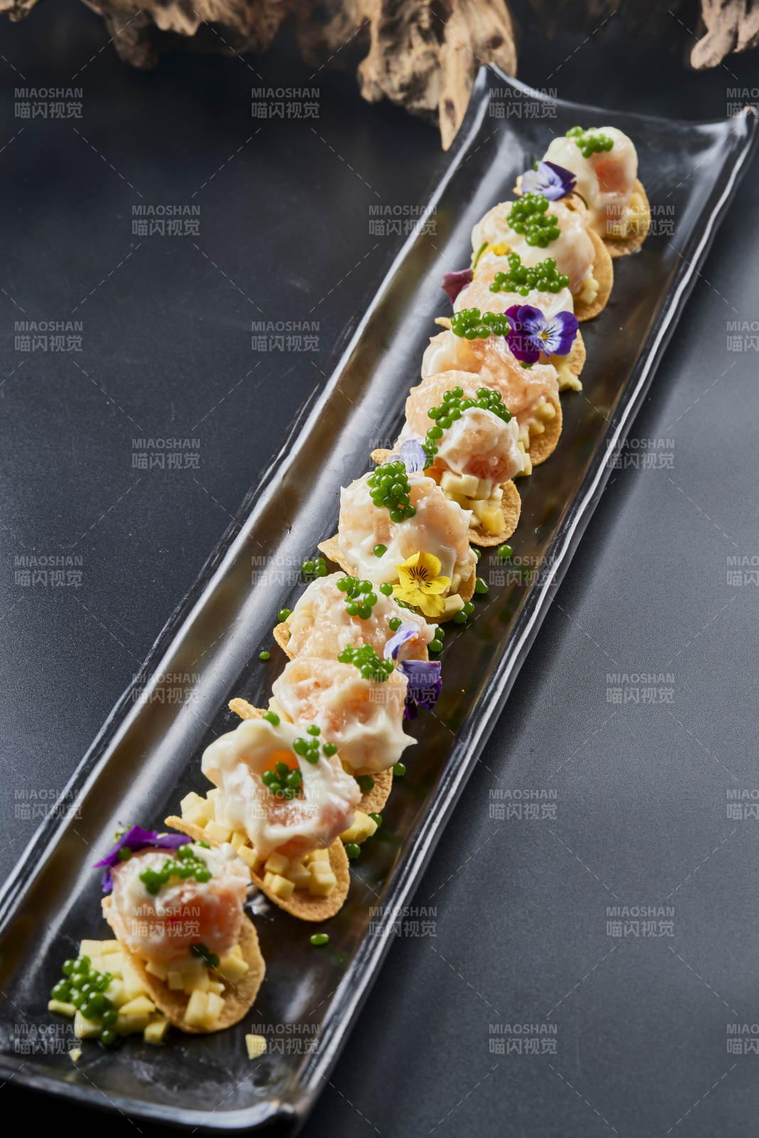 黑色長瓷盤裝的青魚子奶香芝士薯片焗蝦仁