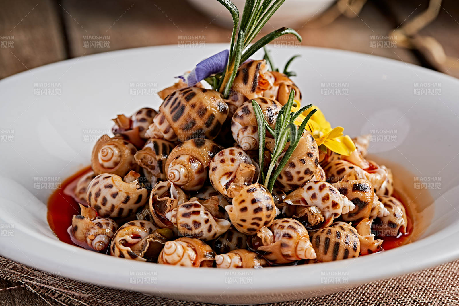 白色瓷盤裝的紅油腌漬小花螺