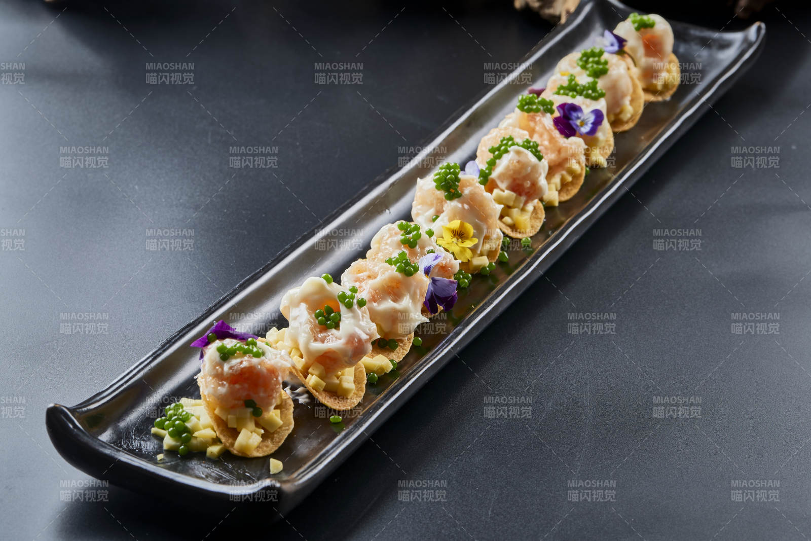 黑色長瓷盤裝的青魚子奶香芝士薯片焗蝦仁