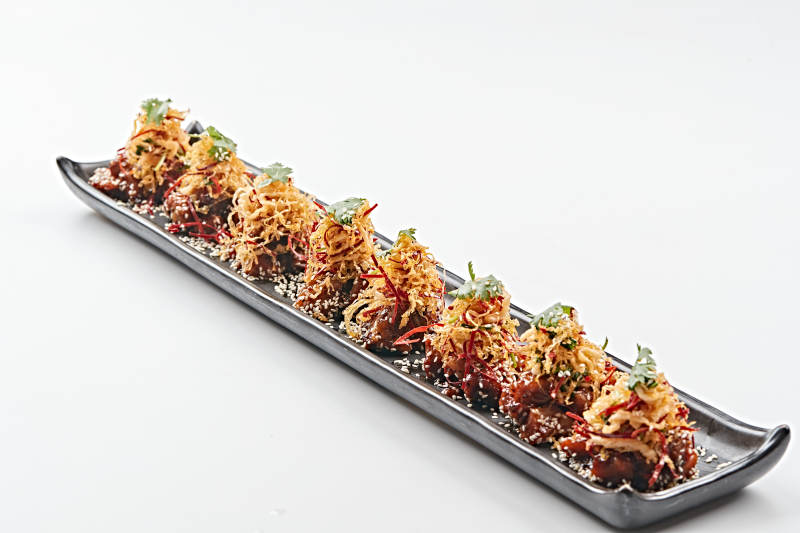 黑色长石盘装的油炸酸菜猪月牙骨