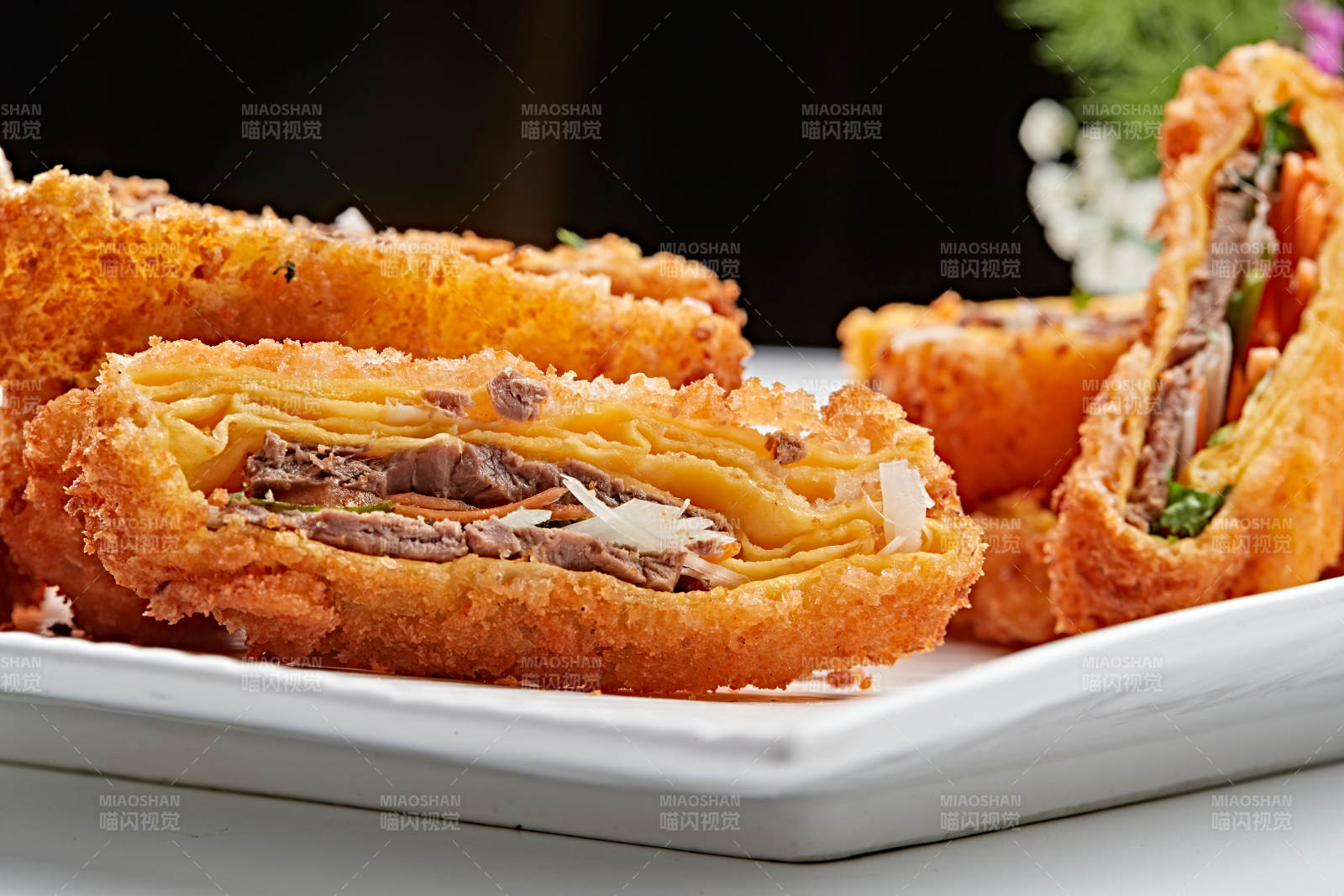 白色瓷盘装的蛋饼香炸小驴肉