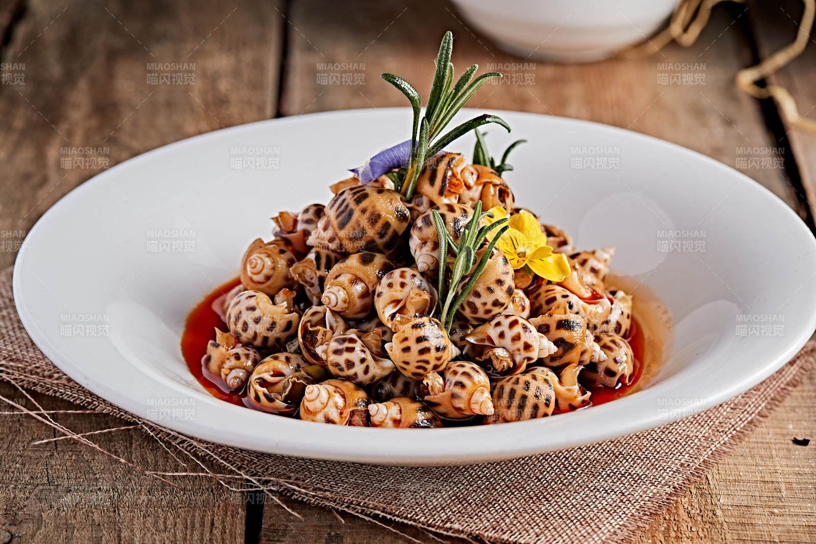 白色瓷盤裝的紅油腌漬小花螺