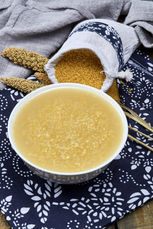 手持木勺㧟起的美味香浓小米粥