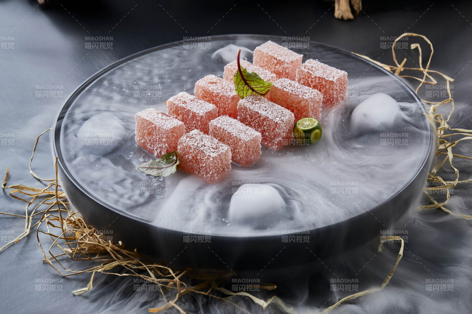 干冰缭绕的黑瓷餐具摆放的番茄糖霜江米糕