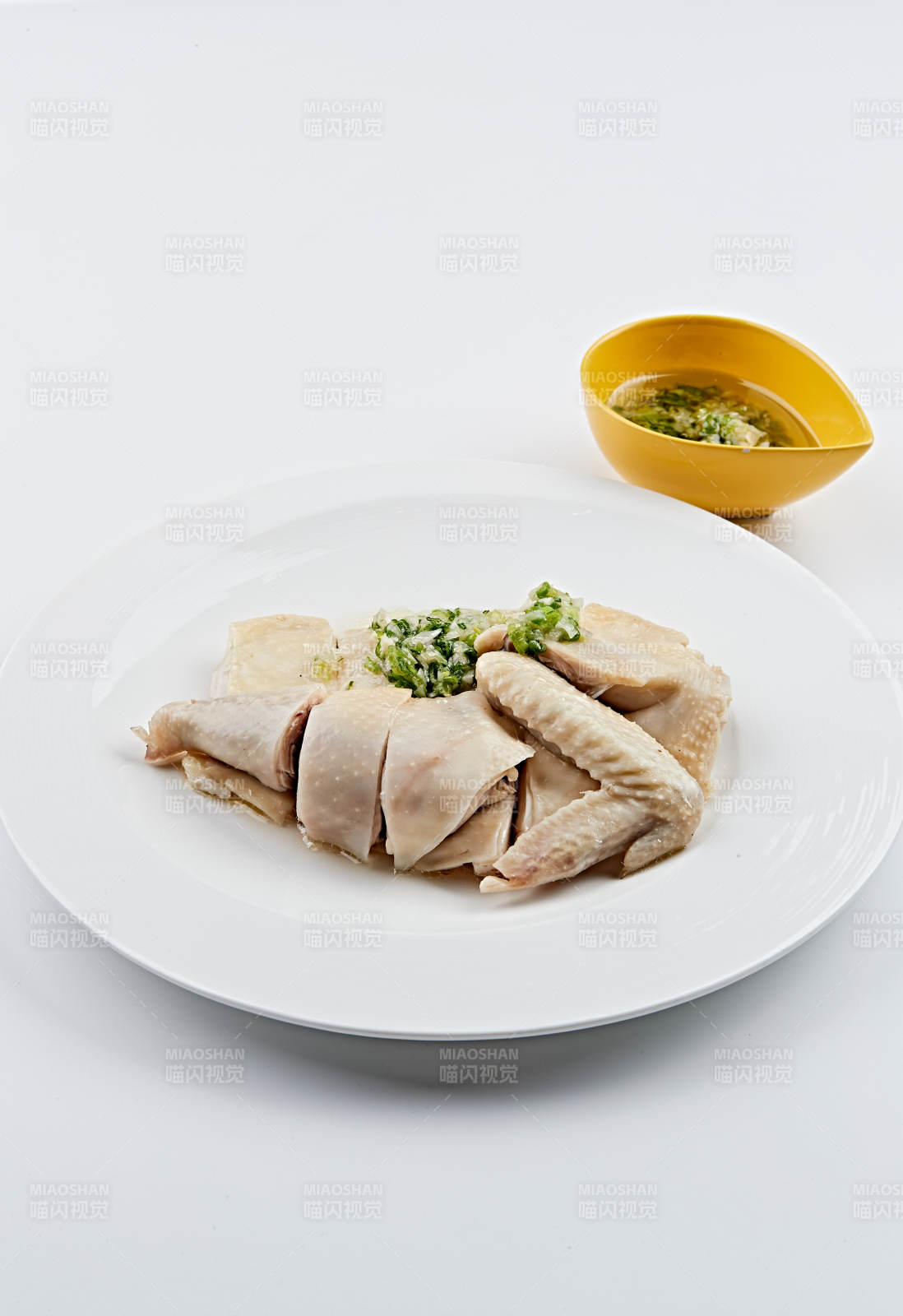 白色盘装的广式蘸汁白切鸡