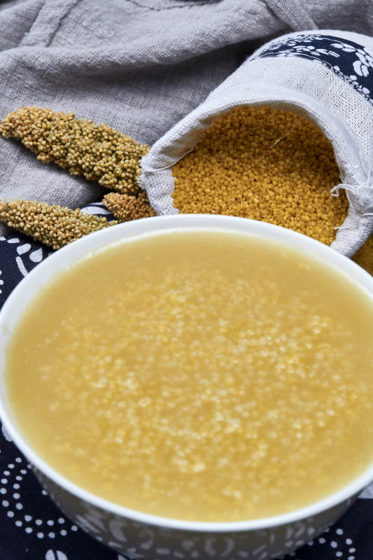 手持木勺㧟起的美味香浓小米粥