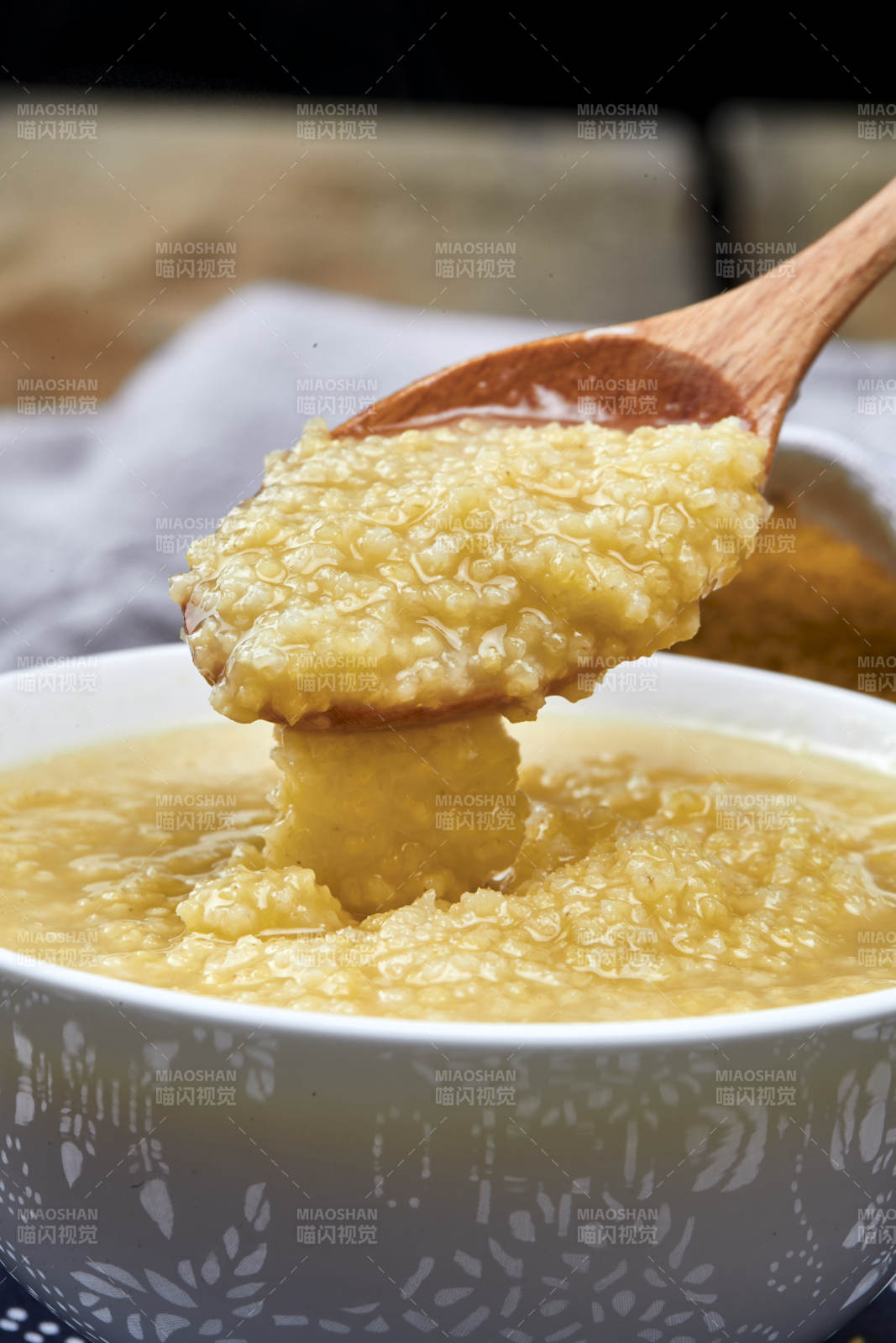手持木勺㧟起的美味香浓小米粥