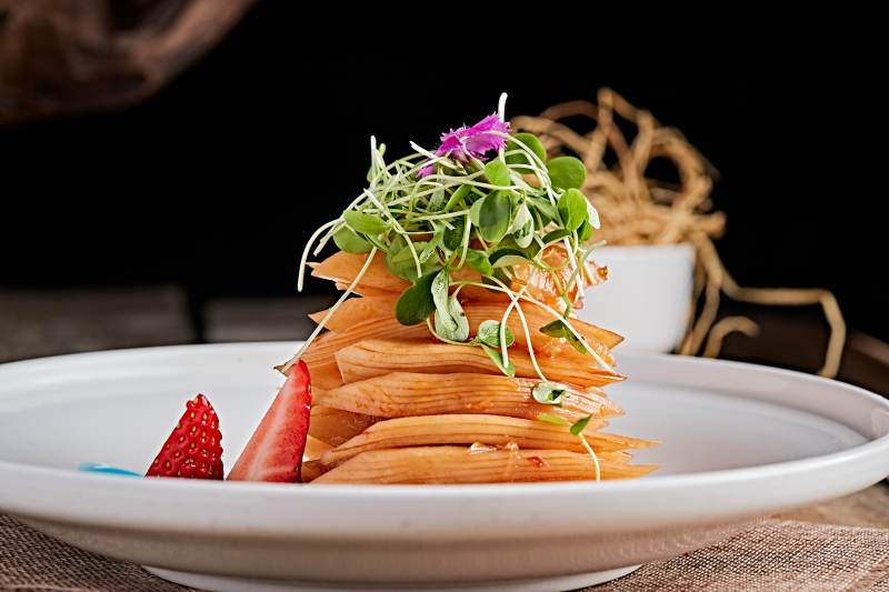 白色瓷盘装的红油香辣萝卜片