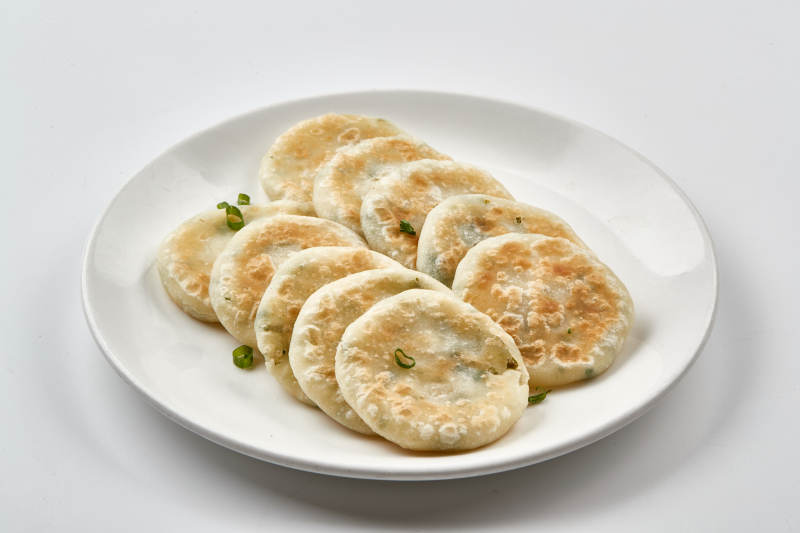 白色瓷盘装的现烙葱油饼